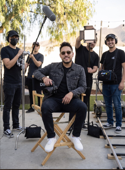 Jonathan Ramirez seated in a director's chair with camera in hand and the Murrieta Media crew holding boom mic and lights on an outdoor set — video production team in Murrieta and Temecula, Southern California